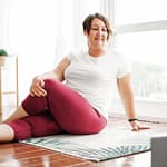 Yoga Helps Create a Calmer Mind. Here is a brunette woman practices yoga with body positivity with a laptop at home for online yoga. Yoga Blog