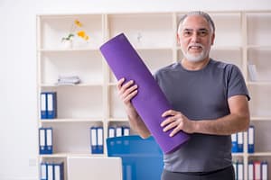 older man holding purple yoga mat for purple chakra balancing