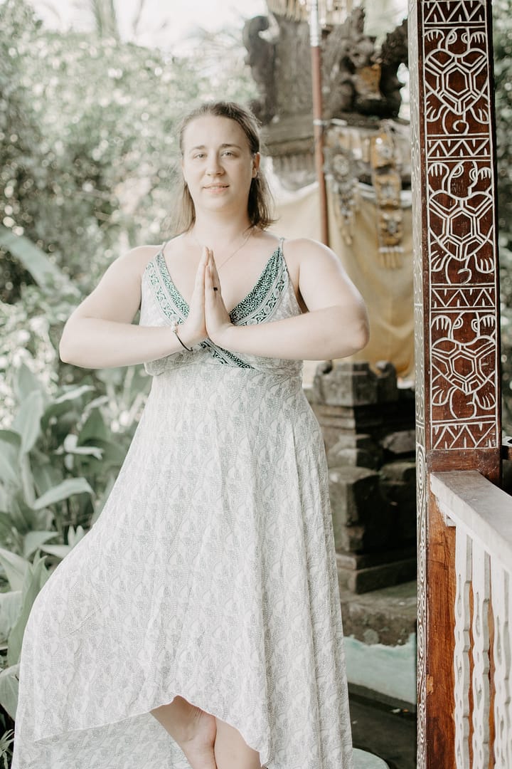 Jennifer Dempsey in a wedding dress prayer hands doing tree pose