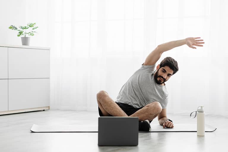 man doing online yoga teacher training at home
